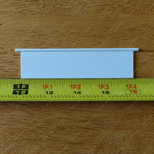 This is a photo of the 4 1/16" wide 1 1/16" tall white colored vent slat with a tape measure placed below it.